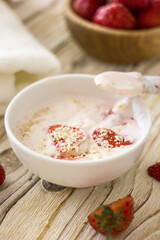 Homemade strawberry face mask. DIY natural home cosmetics mask with oatmeal, cream, strawberries. Authentic wellness cosmetics, natural skin care, non-waste production, sustainable cosmetics