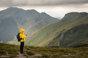 Lost tourist with smart phone using GPS and mobile app for navigation at mountain trail. Woman...