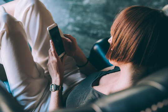 Young woman sitting bar outdoor using smartphone streaming or texting