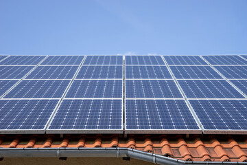 Solar photovoltaic panels on the roof with blue sky in the background