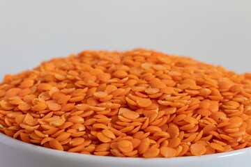 Dhal beans in a white shiny ceramic bowl close up.