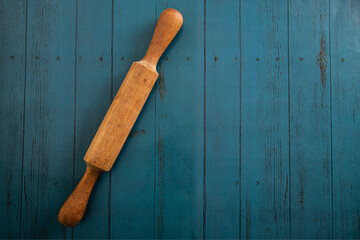 wooden kitchen rolling pin over blue wooden boards