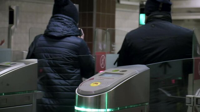 people using electronic touch card to pass through submay turnstile after green light. metro wicket control panel, paying for entrance. title says in russian ONLY IN MASK AND GLOVES