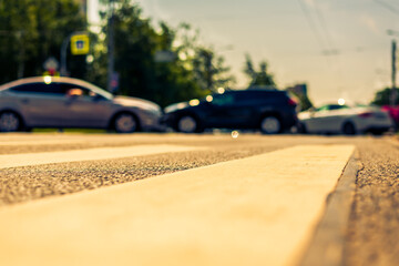 Summer in the city, the cars go along the avenue. View from the pedestrian crossing level