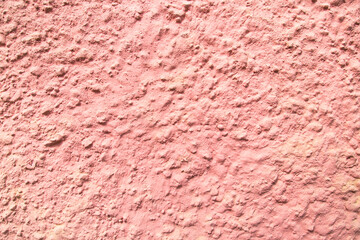 Background of pink painted relief wall with bulges of various sizes, rough finish. Backgrounds design textures.