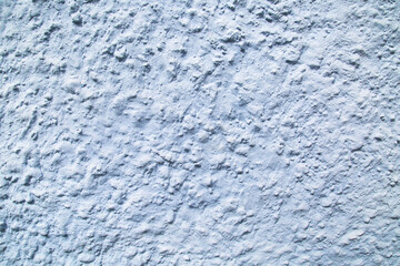 Background of blue painted relief wall with bulges of various sizes, rough finish. Backgrounds design textures.