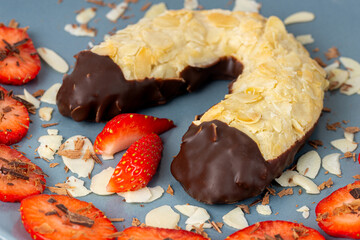 chocolate dipped almond horn with strawberries on a plate