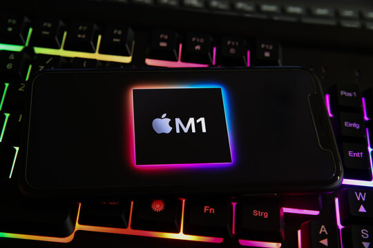 Viersen, Germany - May 8. 2021: Closeup of smartphone with logo lettering of apple M1 processor cpu on computer keyboard