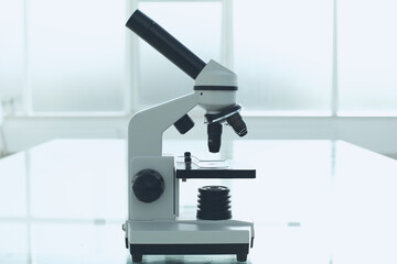 Microscope on a glass table in a bright room. Laboratory medical research concept