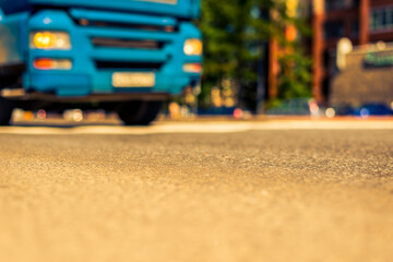 Summer in the city, the truck traveling on the avenue. Close up view from the asphalt level