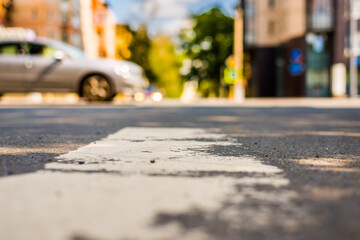 Summer in the city, the car passes by on the road. View from the pedestrian crossing level