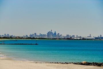 Southern view of the Sydney skyline on a hazy summer day, seen from the shoreline of Botany Bay in New South Wales, Australia.