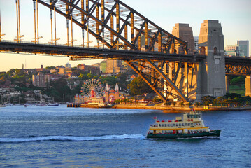 A Sydney Harbour ferry cruising past the Harbour bridge on a early evening run in Sydney, Australia.