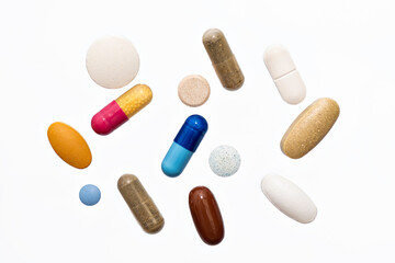 Close-up colorful powder soft capsules pill vitamin blue pink yellow brown supplements on white background