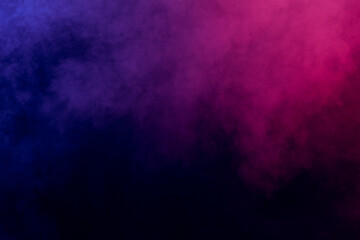 Magic smoke in red-blue light on black background in darkness