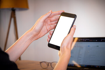 woman hands holding usings smartphone at home with laptop on table, online shopping