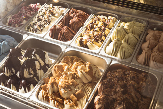Selection of two rows of ice cream of different flavours in stainless steel containers
