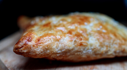 an appetizing pie lies on a wooden board, close-up shot