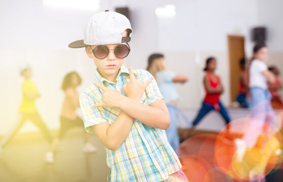 Portrait of cute preteen boy training modern street hip-hop during group dance lesson ..
