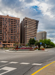 Detail of avenue with buildings in an urban area with a cloudy sky at sunset. Landscaped area with flowers, trees and shrubs.