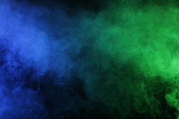 Magic smoke in blue green light on black background