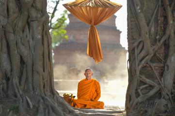Monk Buddhist on during sunrise at temple, Thailand