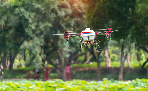 agriculture drone carry a tank of liquid fertilizer flying in the blue sky prepare to spray it in farming area
