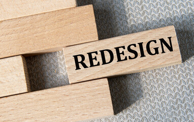 REDESIGN - word on a wooden bar on a gray background