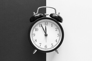 Classic alarm clock on black and white background. Time concept.