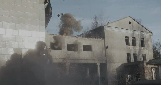 Explosion of an artillery shell from falling into an abandoned building which sheltered the military division. Concept: attack of militants on an opponent. Concept: militants attack on rival. 4k shot 
