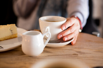 cup of coffee in a fragile female hand in a restaurant