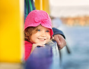 Happy Caucasian little girl smiling. Little girl travelling with parents on the ferry. Vacations concept.