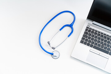 From above modern medical workspace with laptop and stethoscope on desk in hospital