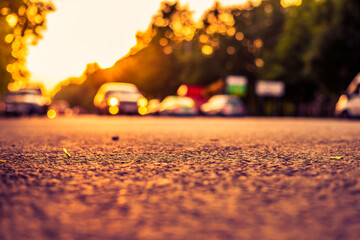 Sunset in the suburbs, the car rides on the highway. Close up view from the asphalt level