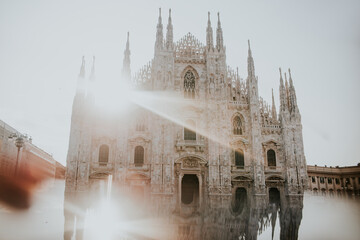 Old masonry church exterior with ornament between buildings under shiny sky in Milan Italy