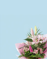 A bouquet of fresh  pink and white lilies. Creative pastel colored concept of flowers on soft blue background.