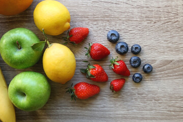 Various colorful fruit on wooden background. Flat lay.