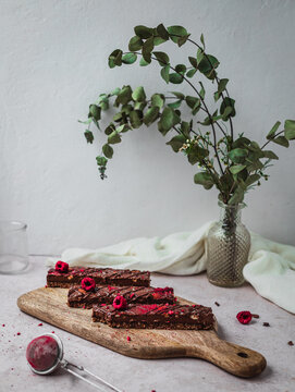 Close up of several chocolate bars with raspberry on a table