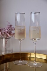 two glasses of champagne and pink flowers