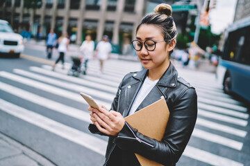 Millennial female blogger in optical spectacles connecting to 4g inetrnet for making online booking...