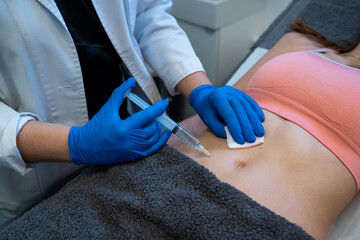 From above of crop anonymous professional beautician making injection for woman during cellulite treatment in beauty clinic