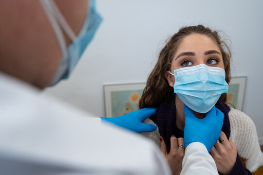 Unrecognizable medic in gloves examining lymph nodes of female patient during appointment in modern hospital