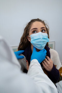 Unrecognizable medic in gloves examining lymph nodes of female patient during appointment in modern hospital