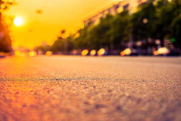 Sunset in the city, the empty road. Close up view from the asphalt level