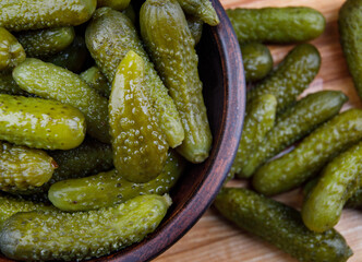 Juicy crispy pickled cucumbers on a wooden cutting board. Salted cucumbers.