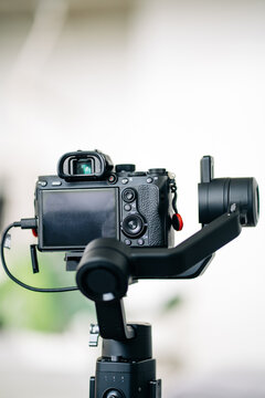 Contemporary digital photo camera with mode dial and viewfinder above display on blurred background