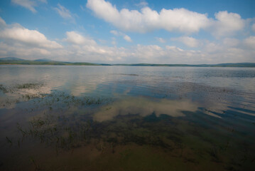 Calm lake view in a cloudy clear sky.