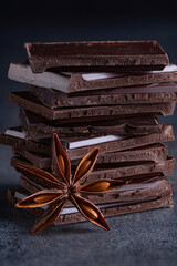 Close up of dark chocolate pieces  and anise on dark marble background.