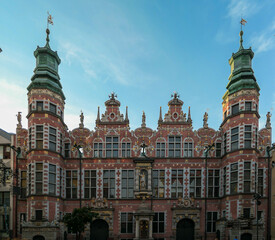 A close up of the facades of great armoury building in the middle of Old Town in Gdansk, Poland. The building is richly decorated. There building has many spikey towers. Renaissance building