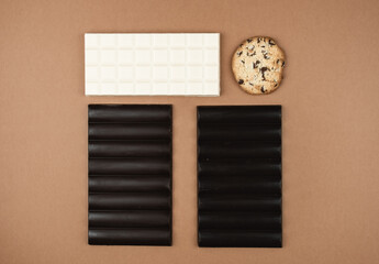 Several bars of white, milk and black chocolate on a brown background. Cover chocolate. International chocolate day.